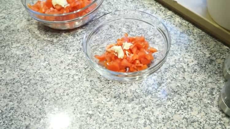 Para cocinar pescado en griego, prepare una mezcla de tomates y ajo.