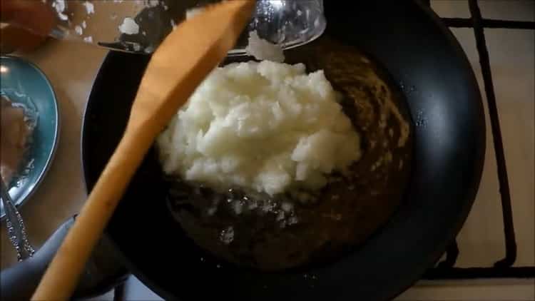 Fry onions to make chicken satsivi in ​​Georgian