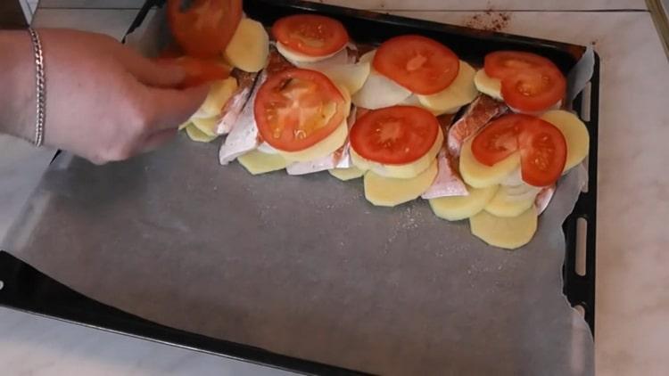 Pour faire cuire le saumon avec les pommes de terre au four, hachez les tomates