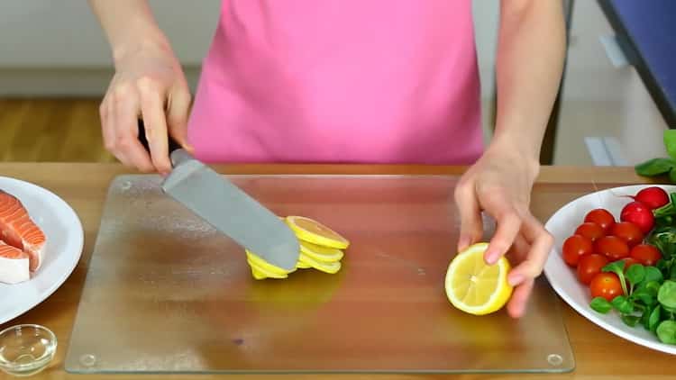 To make a salmon skateboard in the oven, slice a lemon