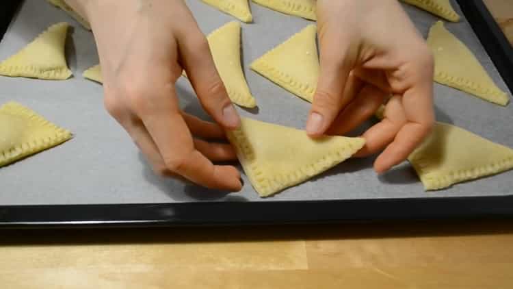 Para hacer galletas de cuajada de sobres, coloque las galletas en una bandeja para hornear