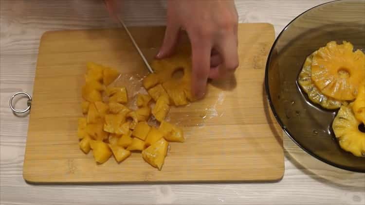 Da biste napravili tortu za pancho s ananasima i orasima, narežite ananas