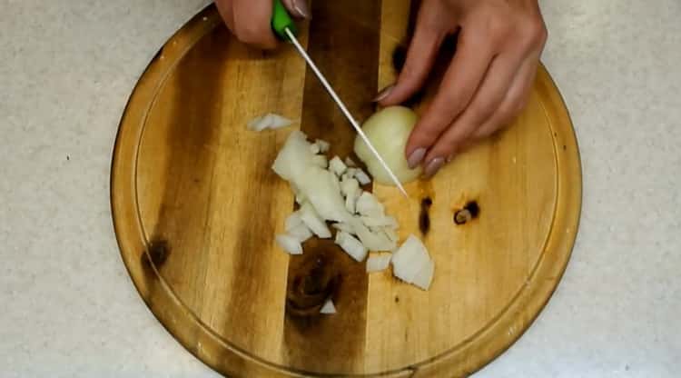 Para cocinar chucrut estofado, picar la cebolla