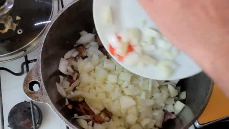 Para hacer pilaf uzbeko a partir de carne de cerdo, picar cebolla