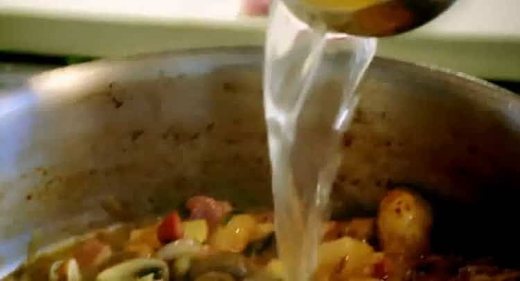 Προσθέστε το ζωμό για να κάνετε κουνέλι fricassee