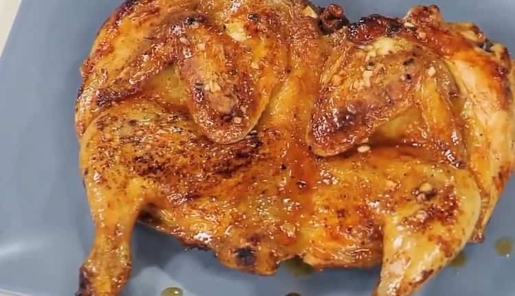 Delicioso pollo al tabaco cocinado de acuerdo con una receta simple en una sartén está listo