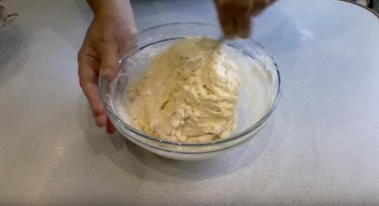 Nous commençons à ajouter de la farine et à pétrir la pâte.