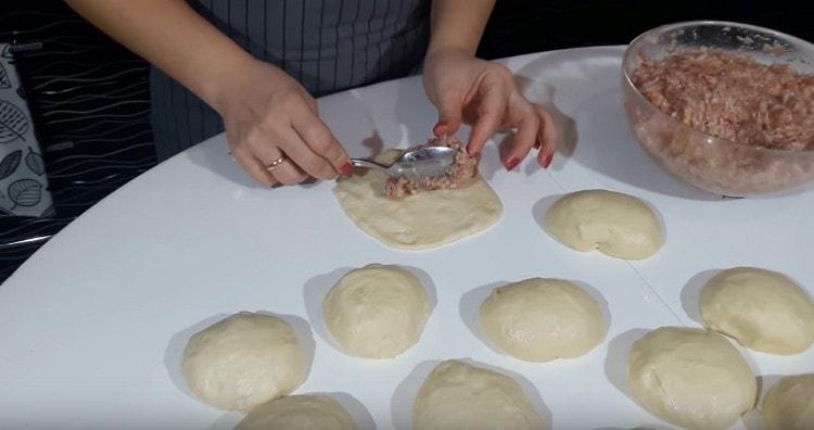 With our hands we level the balls of dough into cakes, on the center of which we place the filling.