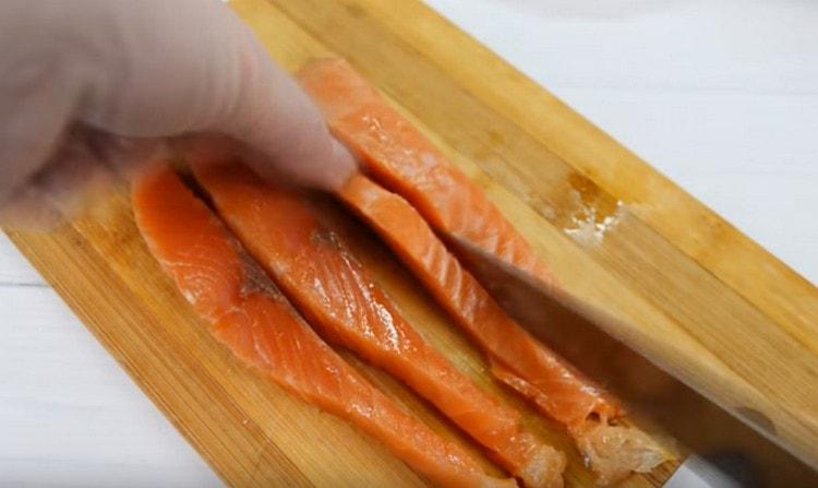 Cortar el filete de salmón en rodajas largas.