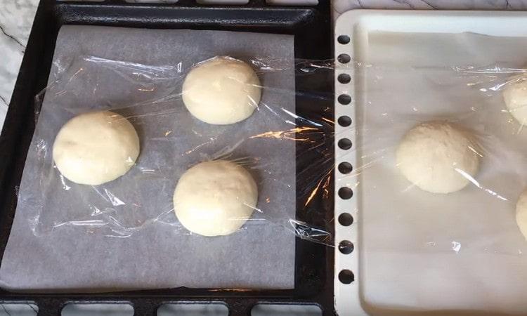 Covering the buns with cling film, let them rise again.