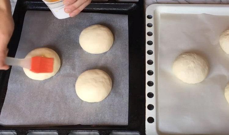 Grease the buns with a mixture of yolk and milk.