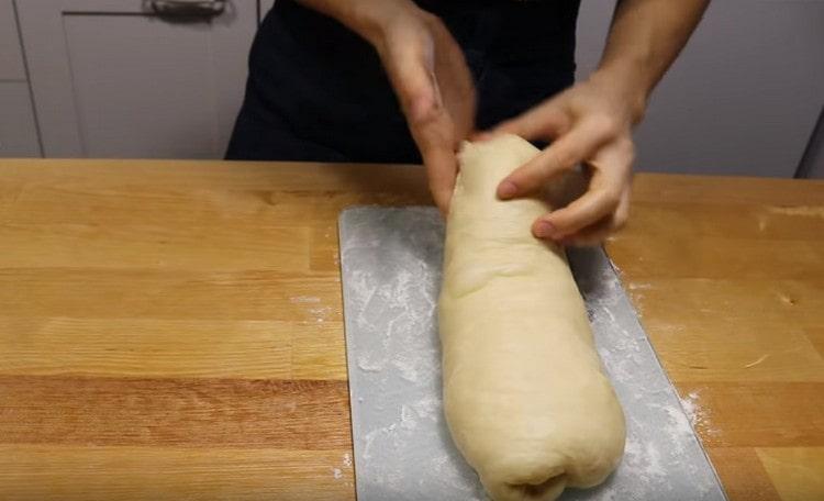 Sous la forme d'un tel rouleau, étalez la pâte sur une assiette saupoudrée de farine.