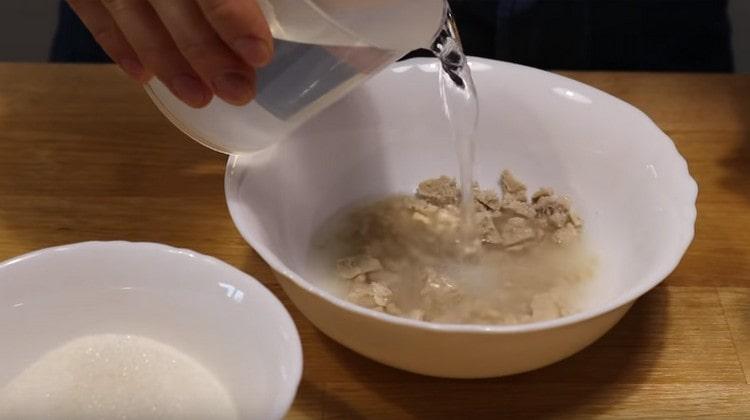 Pour yeast with warm water, add sugar.