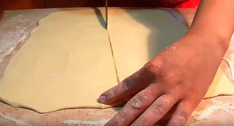 La couche de pâte obtenue est coupée en deux.