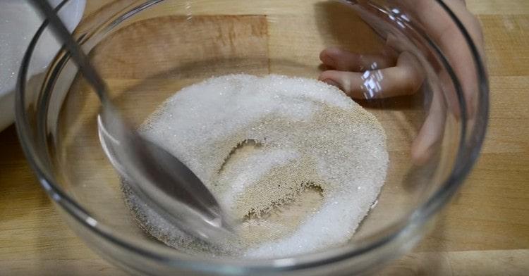 In a bowl, mix yeast with sugar.