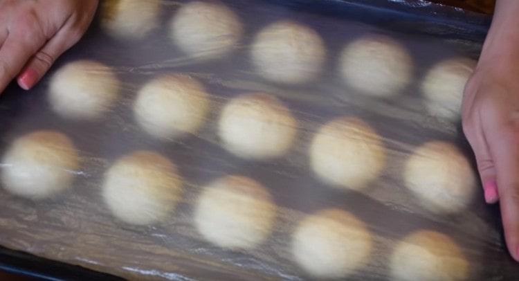 Nous couvrons les petits pains sur une plaque à pâtisserie avec un film et les laissons venir un peu plus.