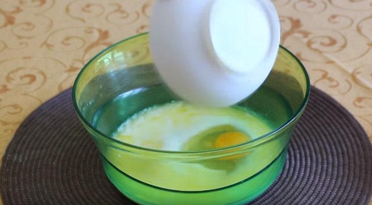En la leche, agregue sal, azúcar, un huevo y mantequilla derretida.