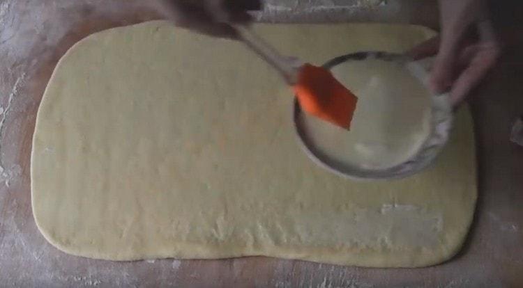 Lubricate the dough layer with melted butter.