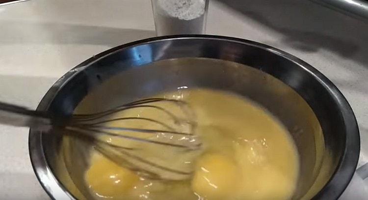 Add two eggs to the butter and beat with a whisk.