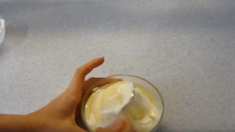 Para preparar el vertido, mezcle la crema agria con leche condensada.