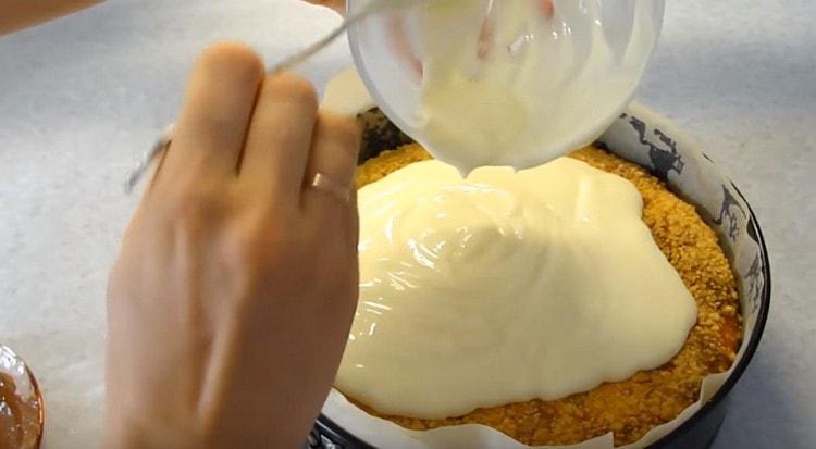 Verser le gâteau au fromage chaud avec un mélange de lait concentré et de crème sure.