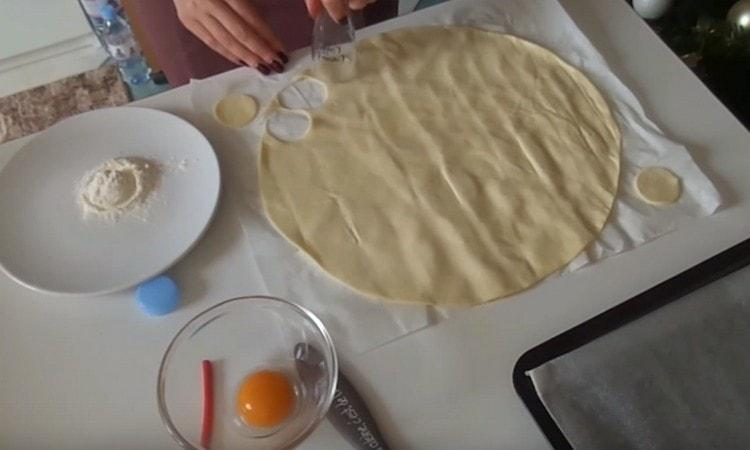 Avec un emporte-pièce ou un verre, nous découpons des cercles dans la couche de pâte.