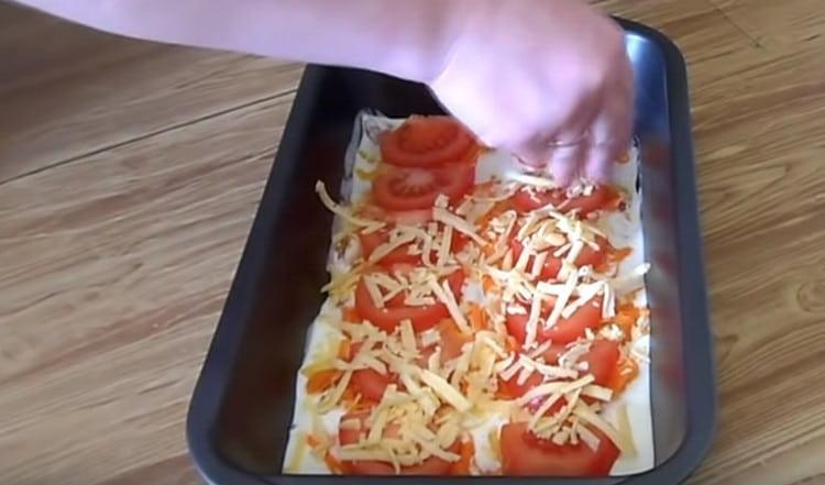 then spread the pieces of tomatoes and sprinkle the dish with cheese.