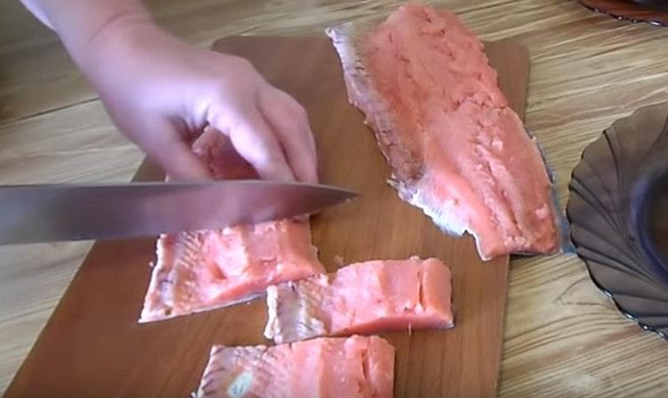 Gupitin ang kulay rosas na fillet ng salmon.