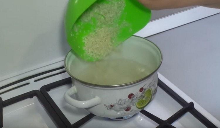 Nous répandons le riz dans de l'eau bouillante et cuisons jusqu'à tendreté.