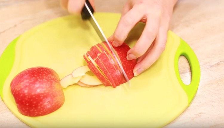 Nous coupons les pommes en fines tranches.