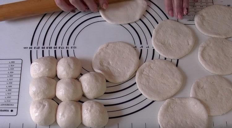 Each ball of dough is rolled into a cake.
