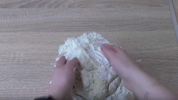 Pour the remaining flour onto the table and knead the dough in it.