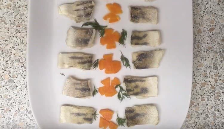 Between pieces of fish, we beautifully lay out decorations from carrots and greens.