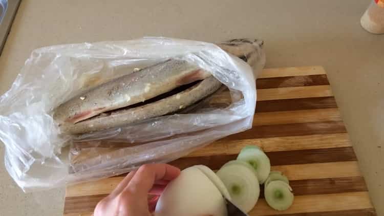 To cook mackerel in foil in the oven, chop the onion