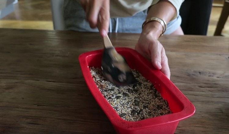 We shift the grain dough into a baking dish.