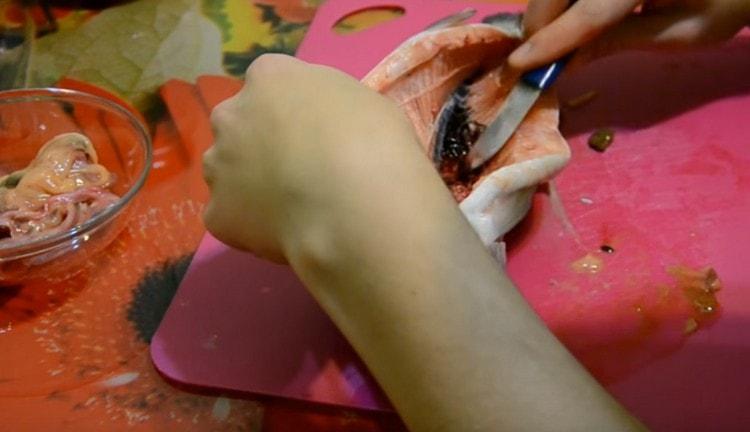Cut the abdomen of the trout and take out the insides.