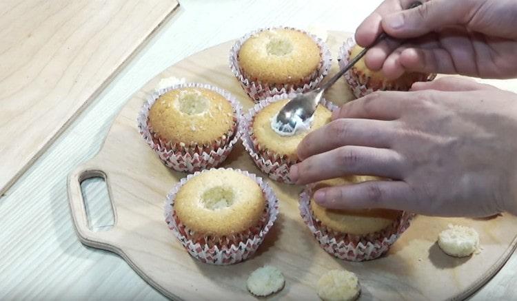 Avec un couteau, coupez soigneusement les entailles dans les cupcakes et remplissez-les de crème.