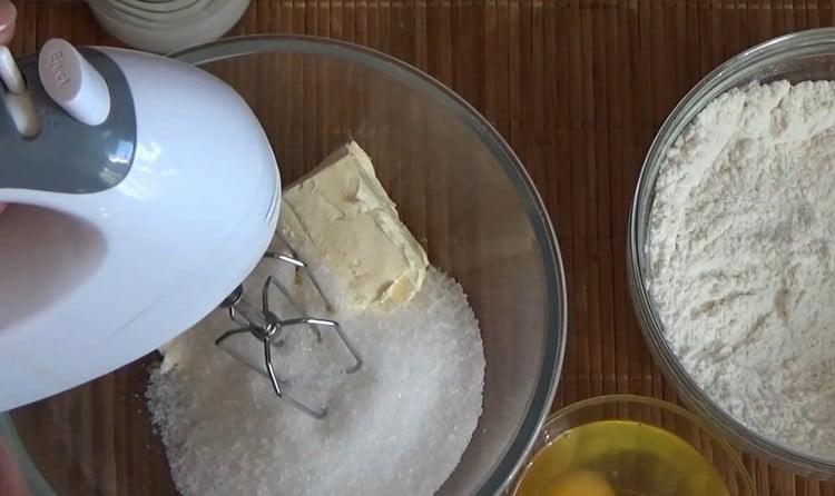 Séparément, battez le beurre avec le sucre avec un mélangeur.