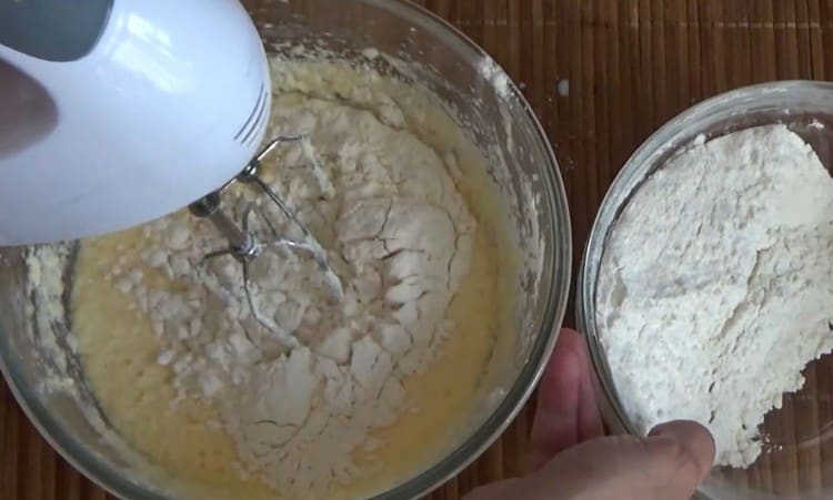 Ajouter la farine par parties et battre la pâte.