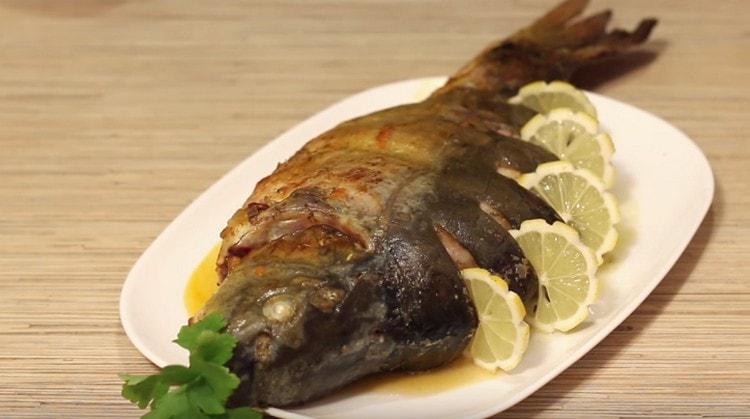 Carp cooked in the oven, when served, can be decorated with lemon slices.