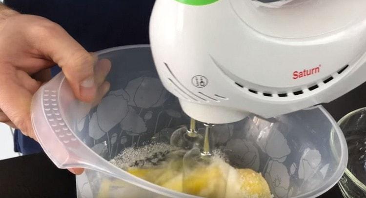 Batir los huevos con azúcar con una batidora.