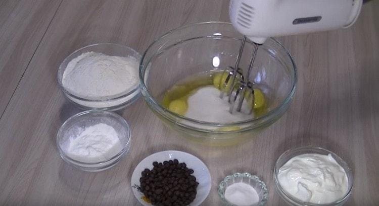 Battez les œufs avec du sucre avec un mixeur.