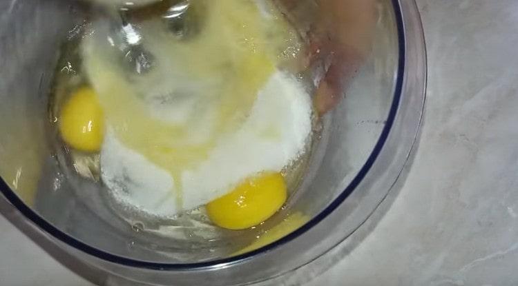 Agregue azúcar a los huevos y bata la masa con una batidora.