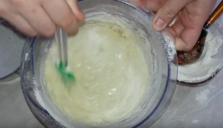 We mix the dough with a spatula, if necessary, add more flour.