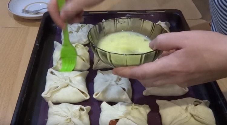 Having laid the blanks on a baking sheet, grease them with an egg.