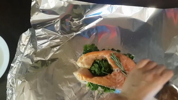 To cook red fish in the foil in the oven, put the fish on cilantro