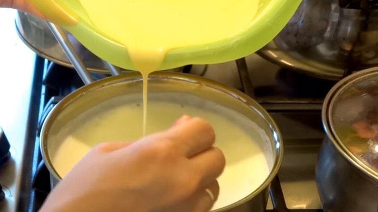 Introduce egg mass into a boiling milk in a thin stream.