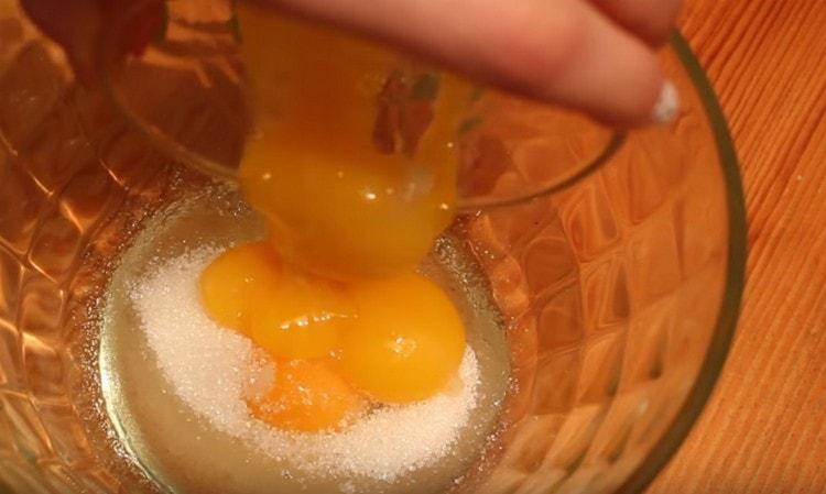 V miske porazíme jedno vajce, pridáme ďalšie tri žĺtky a vanilkový cukor.