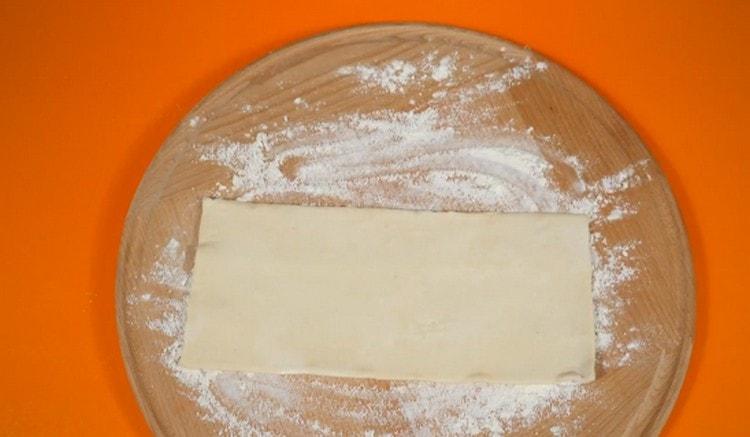 Placez la pâte feuilletée décongelée sur une surface saupoudrée de farine.