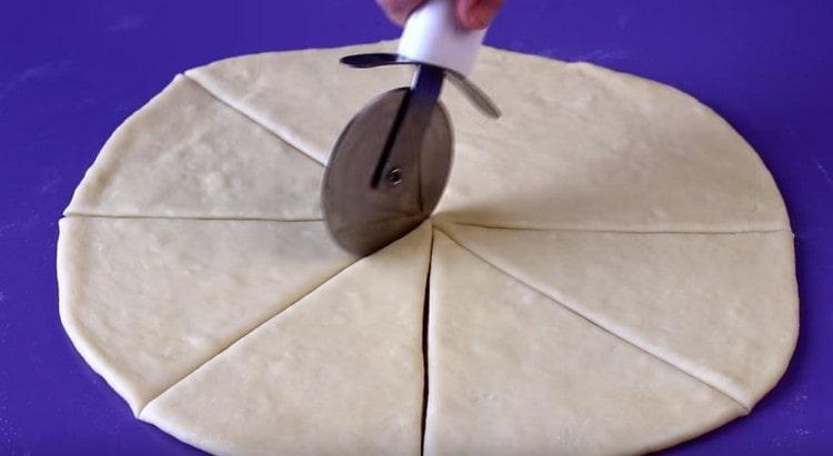 Après avoir enroulé chaque partie de la pâte en un cercle, nous la divisons en 8 secteurs.